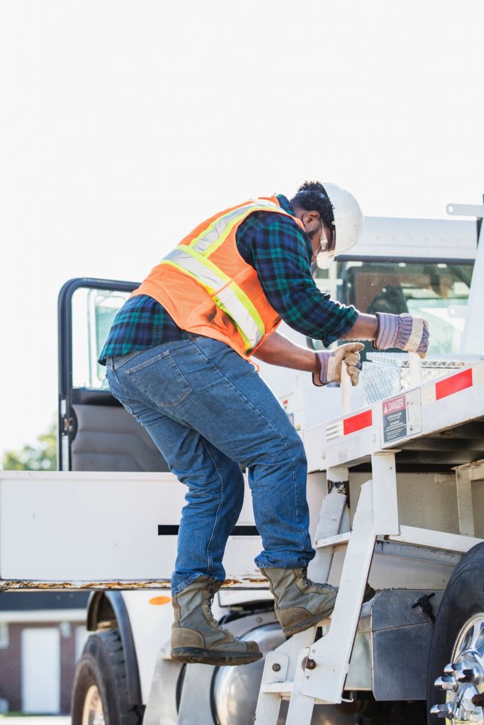 homem subindo uma escada para caminhão